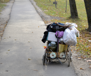 photo of homeless person's worldly possessions in a shopping cart on a sidewalk